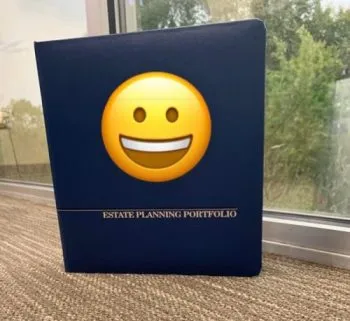 Blue hardcover portfolio labeled "Estate Planning Portfolio" placed on carpet near window.